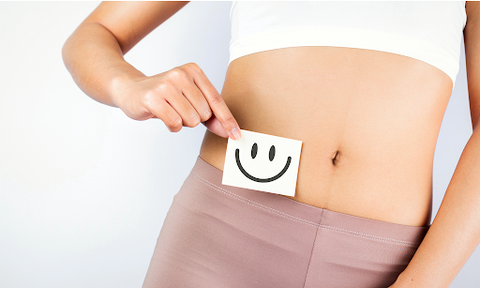 Frau hält sich Smiley vor ihren Bauch