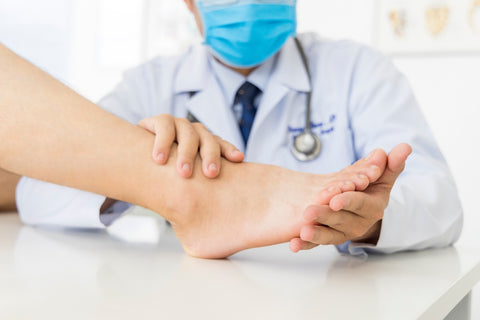 Nagelpilz bekämpfen: Arzt untersucht Fuß eines Patienten
