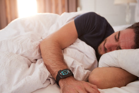 Fitness-Tracker Gesundheit: Mann trägt beim Schlafen eine Fitnessuhr am Handgelenk
